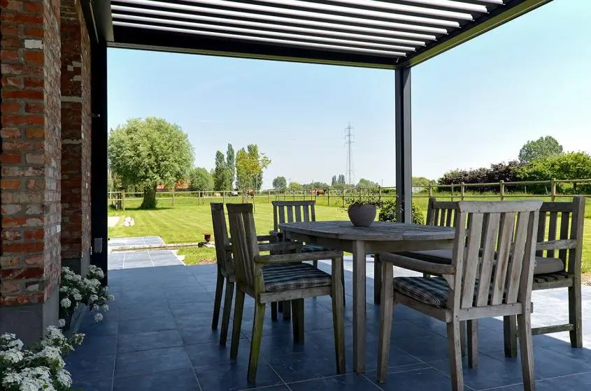 Pergola Ombra - konstrukcja wsparta o fasadę budynku, wyposażona w boczne ekrany